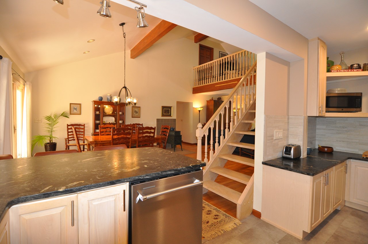 kitchen to dining area this photos shows the location of the dishwasher.  the stairs go up to the family room.