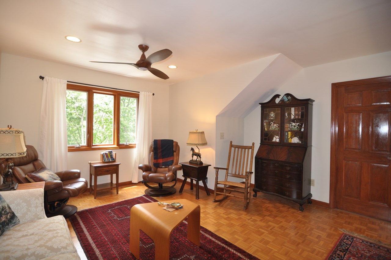 loft style family room the family room on the upper level has a parquet floor and ceiling fan.  along with the attic area to the left is a more spacious, partially finished area through the door to the right that could be used for a variety of things besides storage such as a hobby room.  a window could possibly be added as well.  great extra option!!!