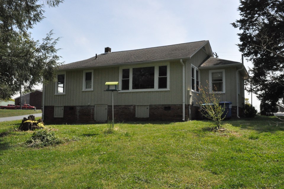 back of the cottage the dwelling is on a crawl space and the windows to the left are for the bedroom and bath, the larger window is for the living room.
