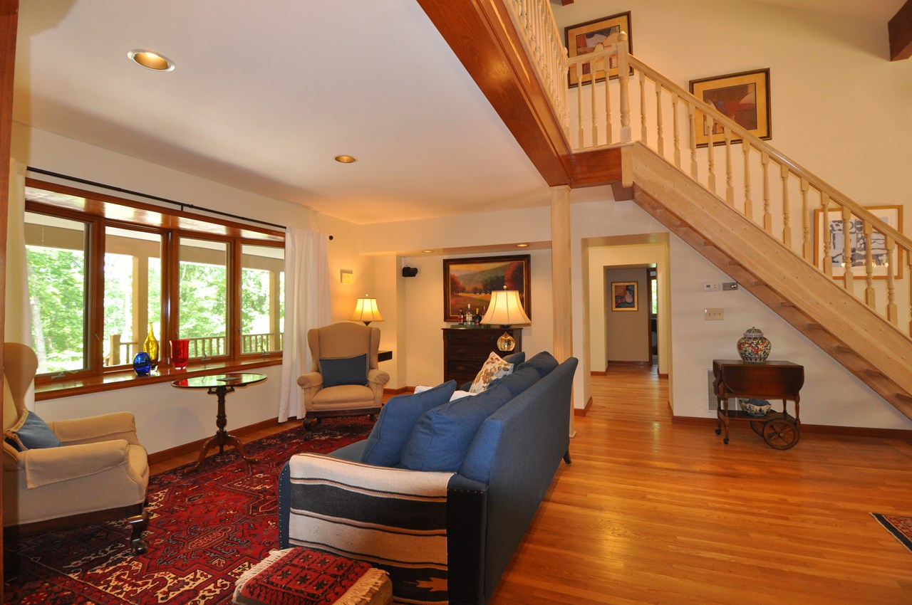 living room to foyer this view of the living room is facing the foyer and beyond the foyer are the two guest bedrooms and bath. the stairs go up to the loft style family room. there is a bay style window in the front.