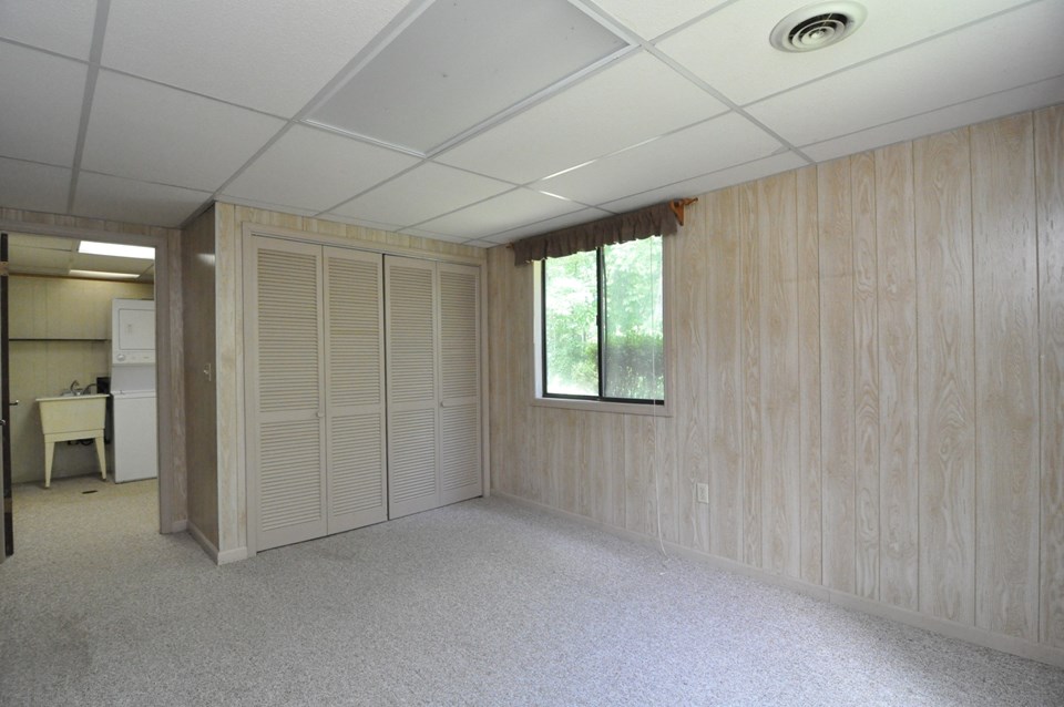 den the den is located at the back left side of the basement and is 10 x 13.  it could be easily used as an extra bedroom.  it has a closet and through the door is a small hall leading to the laundry room and full bath.