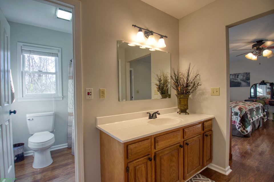 primary bathroom the bathroom is divided into two sides, the commode and tub/shower combination is shown through the door and the part with the sink, additional closet and storage closet are  separated and go directly off the bedroom.